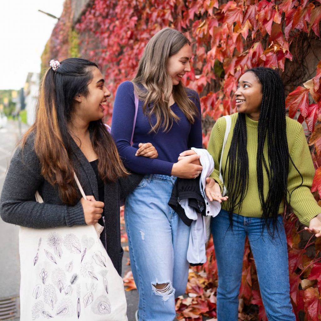 Female students talking whilst walking on campus 