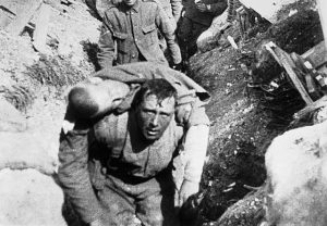 The image shows a soldier carrying a wounded man on his back, this was taken during the Battle of the Somme