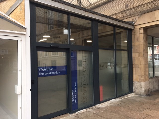 The entrance to The Workstation glass doors with blue signage
